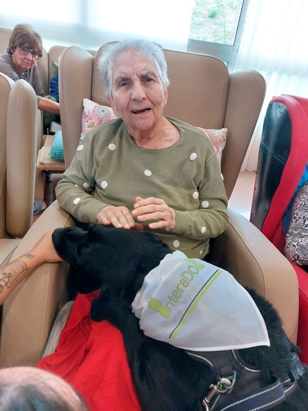 Una residente feliz junto al perro de terapia en Benviure