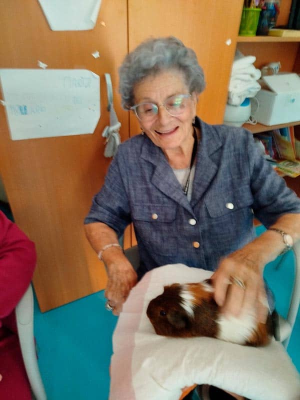 Una residente, feliz, acaricia a un buho de terapia