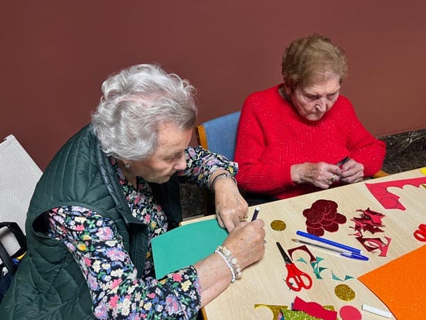 Personas mayores participando en actividades de manualidades en MGS Seniors.