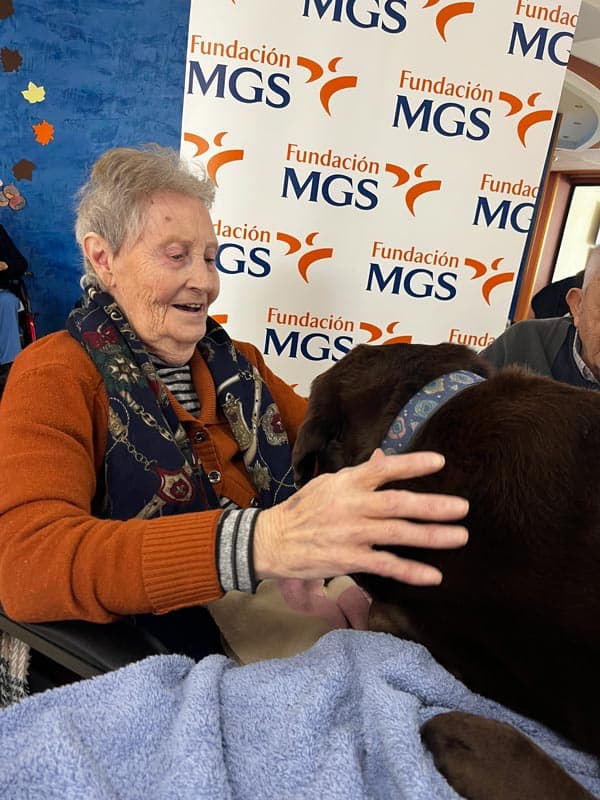 Una residente sonríe mientras acaricia a Roscón