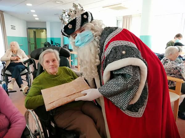 Los Reyes entregan un regalo a una residente
