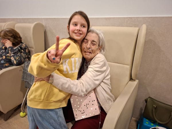 Una residente abraza a su familiar en la sesión de bingo