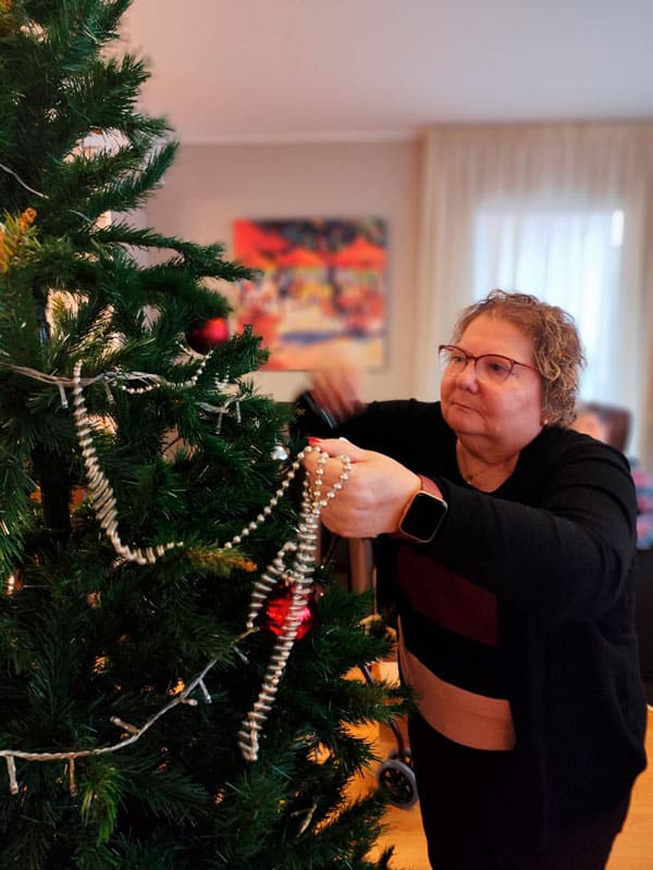 Una residente decora el árbol de la residencia