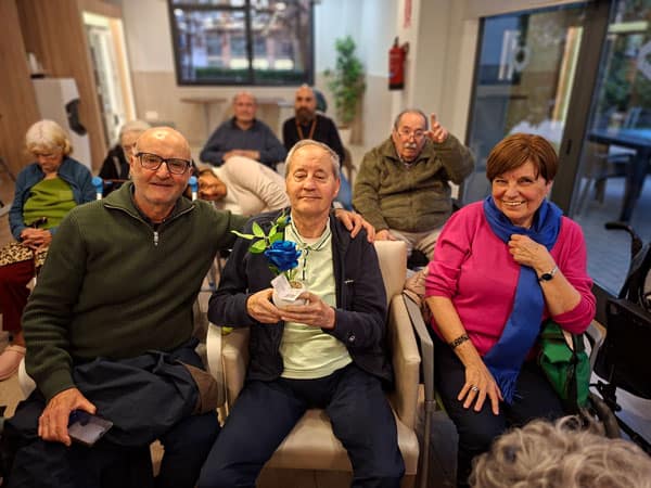 Una residente junto a su detalle de rosa azul