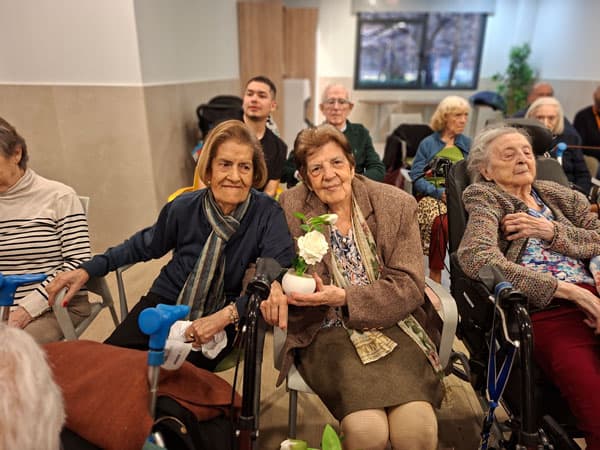 Residente cumpleañera feliz junto a su rosa de color blanco