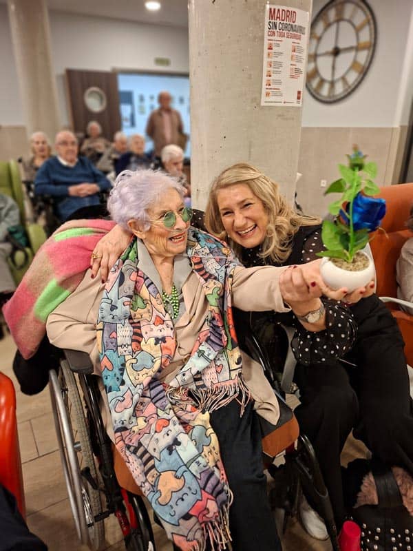 Otra residente ríe con la rosa azul que le regalan por su cumpelaños