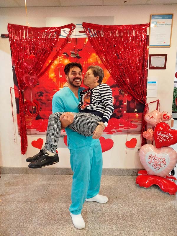 Una residente da un beso en la mejilla a un auxiliar del centro