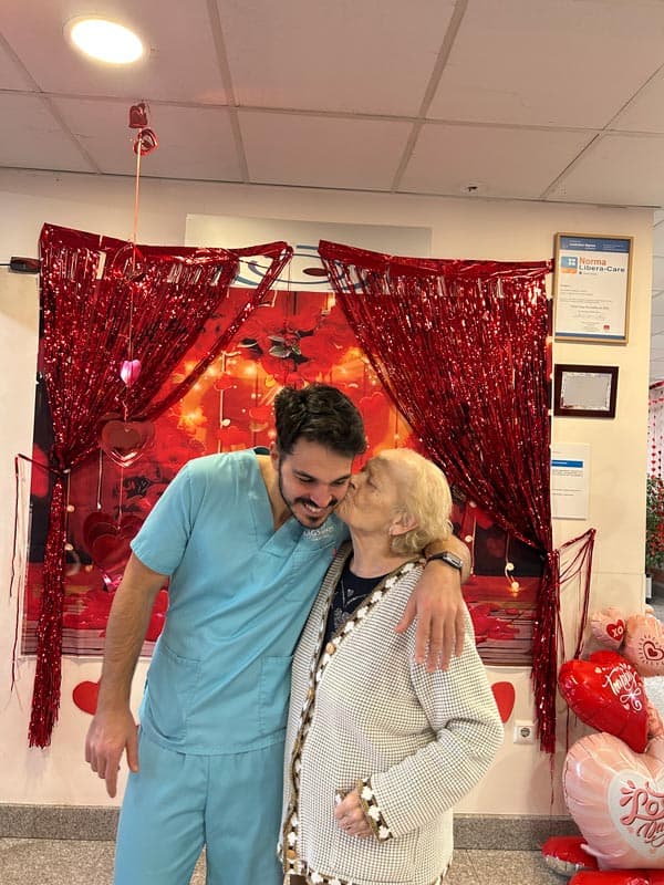 Una residente feliz junto a un auxiliar el día de San Valentín