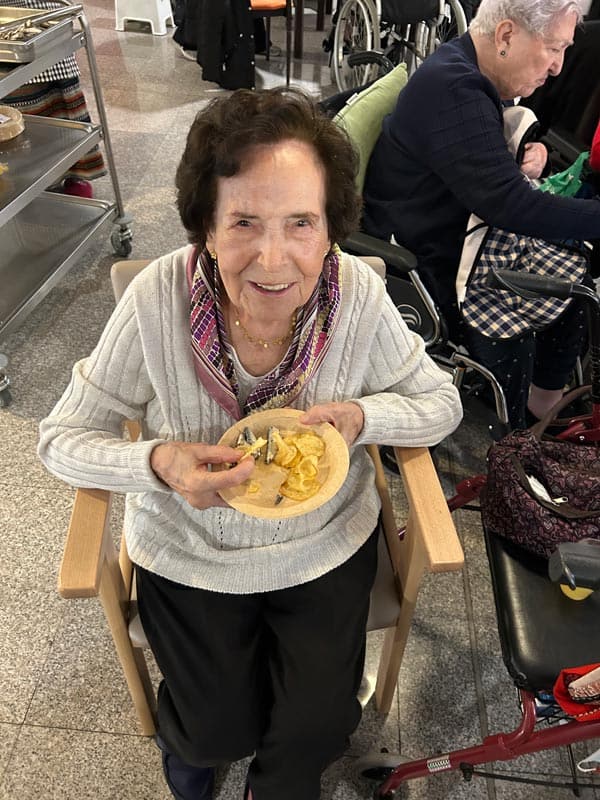 Una residente prueba la comida de la jornada de entierro de la sardina