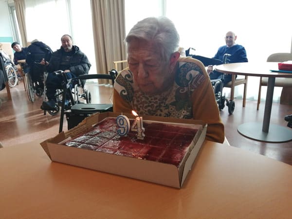 Una residente sopla su pastel por sus 94 años