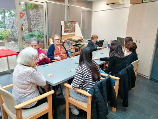 Personas mayores participando en una reunión social en un centro de atención a la tercera edad.