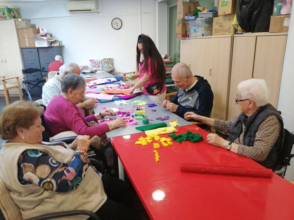 Personas mayores participando en taller de manualidades en Benviure, promoviendo integración y biene.