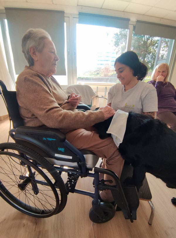 Anciana en silla de ruedas con cuidadora en Benviure.