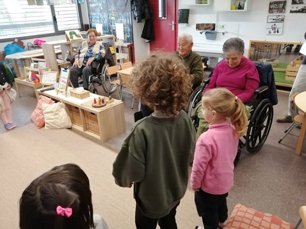 Personas mayores y jóvenes compartiendo actividades en un centro de atención.