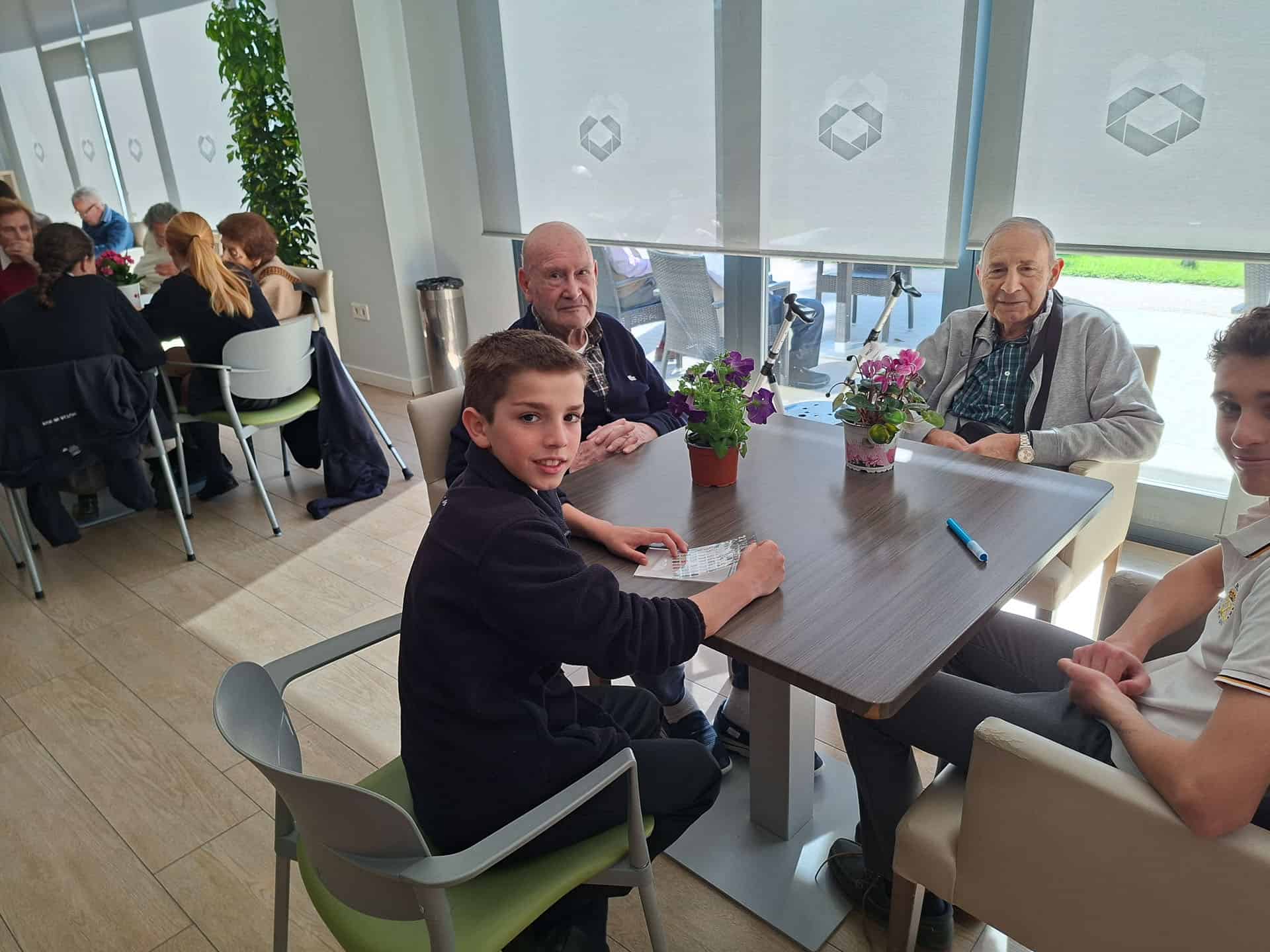 Una joven junto a dos residentes en el comedor el día de la plantación de semillas