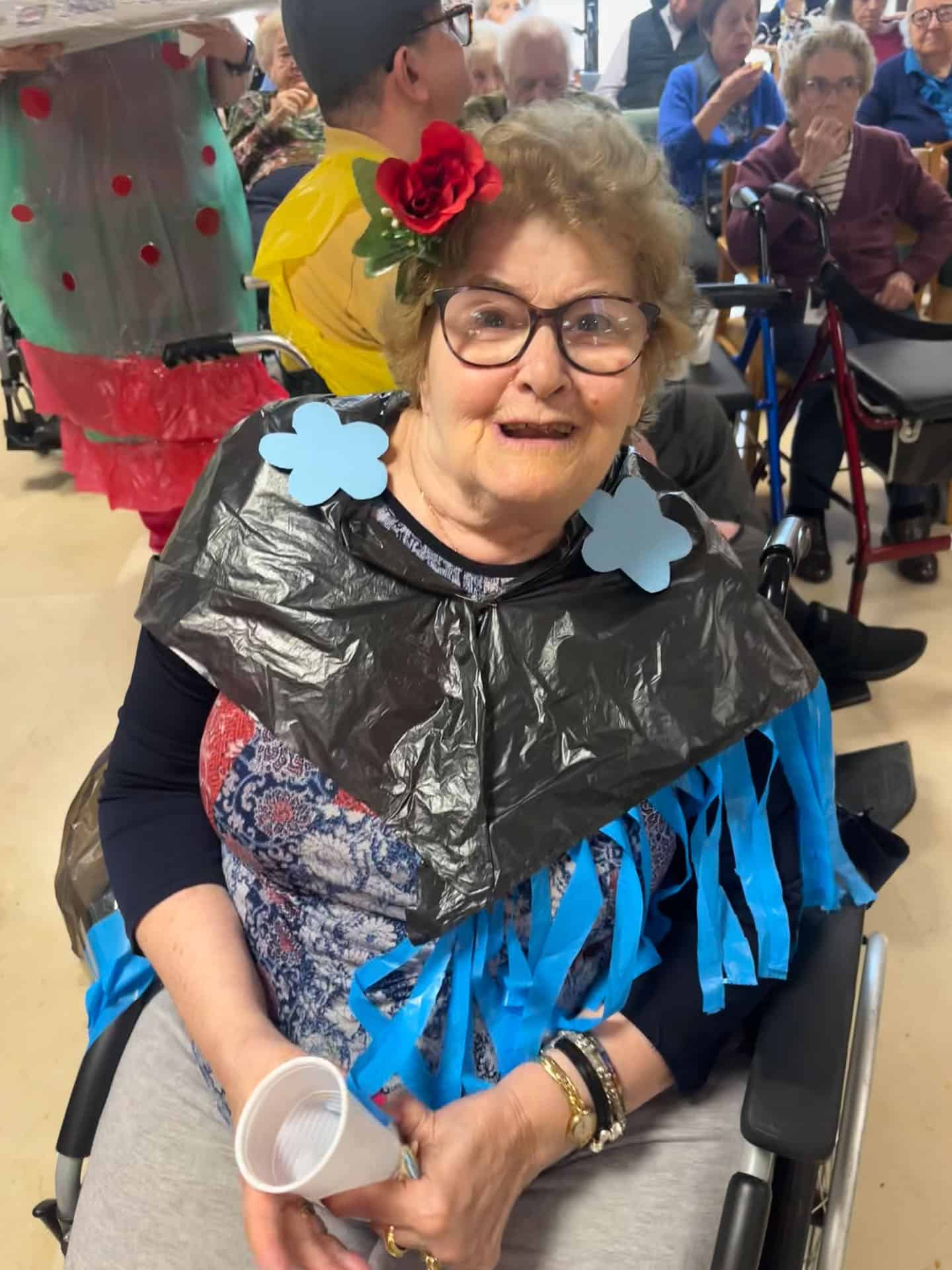 Dona gran disfressada en la Feria de abril amb decoracions florals i vestuari festiu.