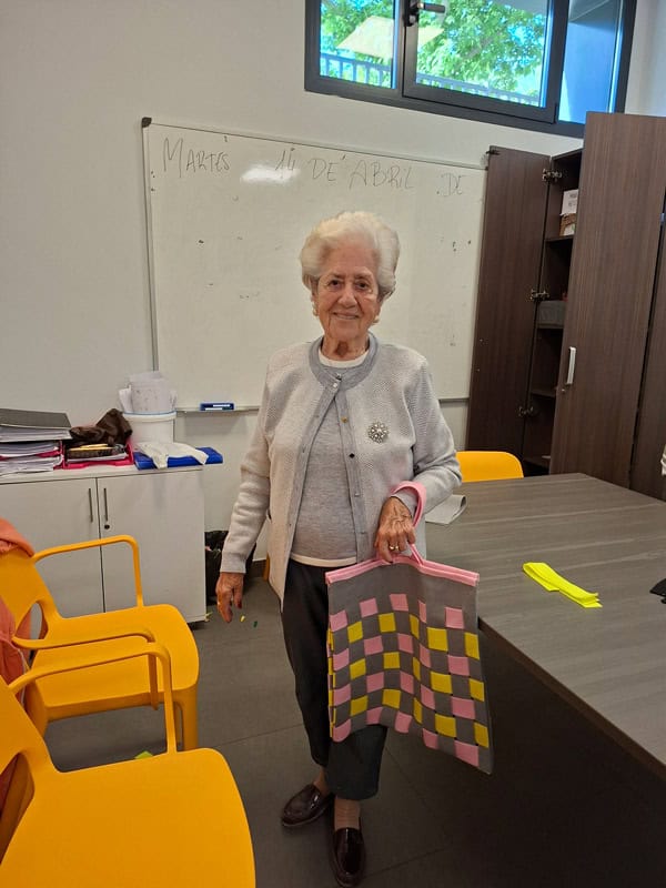 Una residente muestra orgullosa el bolso que ha creado ella misma