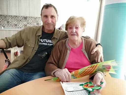 Una residente recibe una rosa de un familiar en Sant Jordi