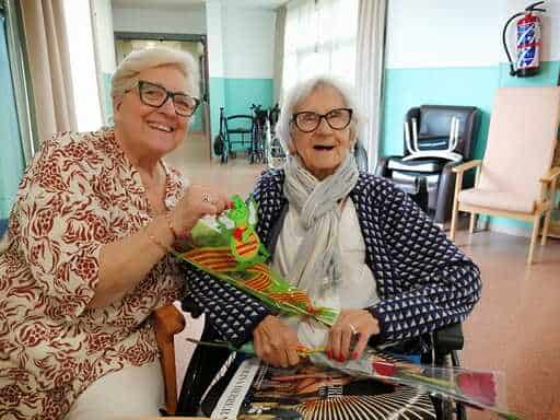 Residentes felices junto a su rosa de Sant Jordi