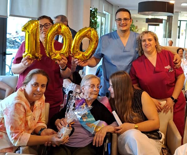 Celebración de 100 años en MGS Seniors con residentes y personal en un evento especial.
