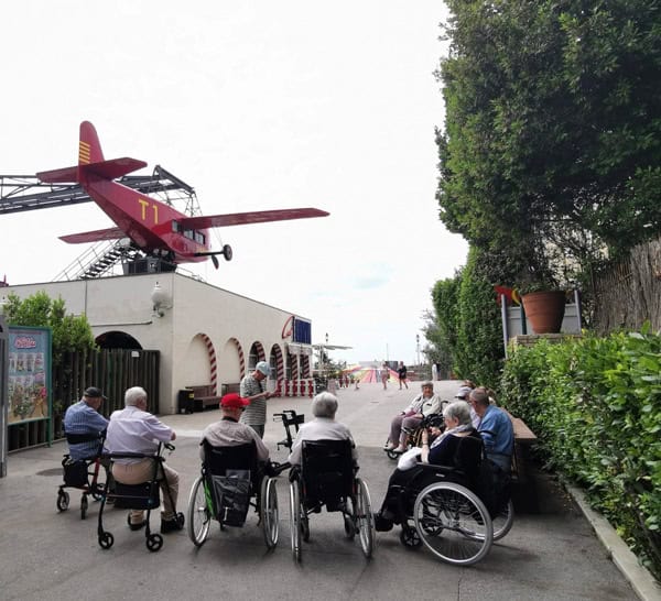 Vista de los residentes desde atrás con la atracción del avión de fondo