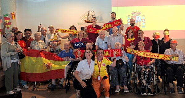 Los residentes y trabajadores muestran felices bufandas y camisetas de España por el mundial de fútbol