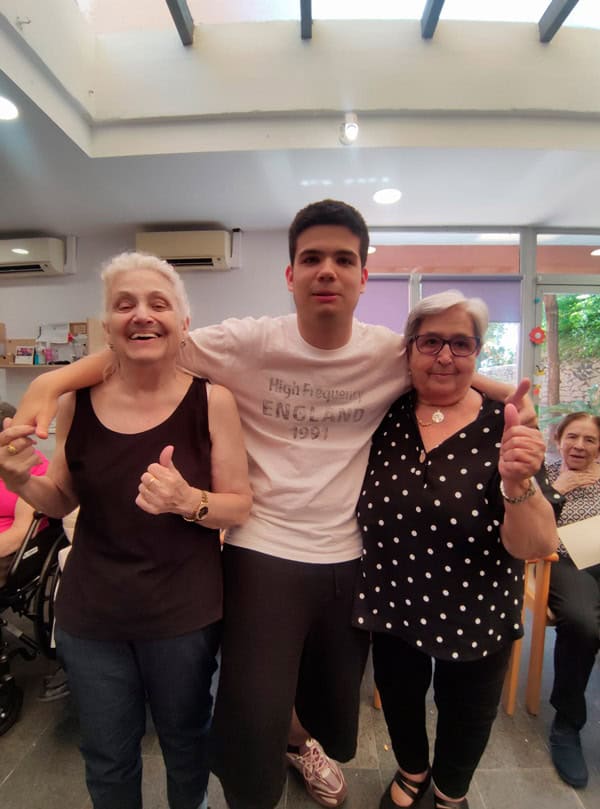 Un alumno posa sonriente junto a dos residentes
