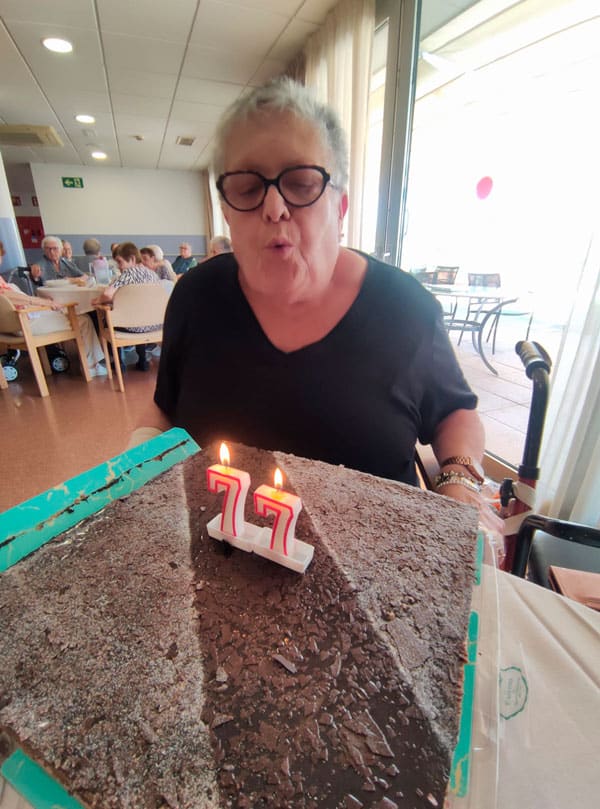 Una residente sopla las velas de su tarta de cumpleaños en una nueva jornada de cumplemes