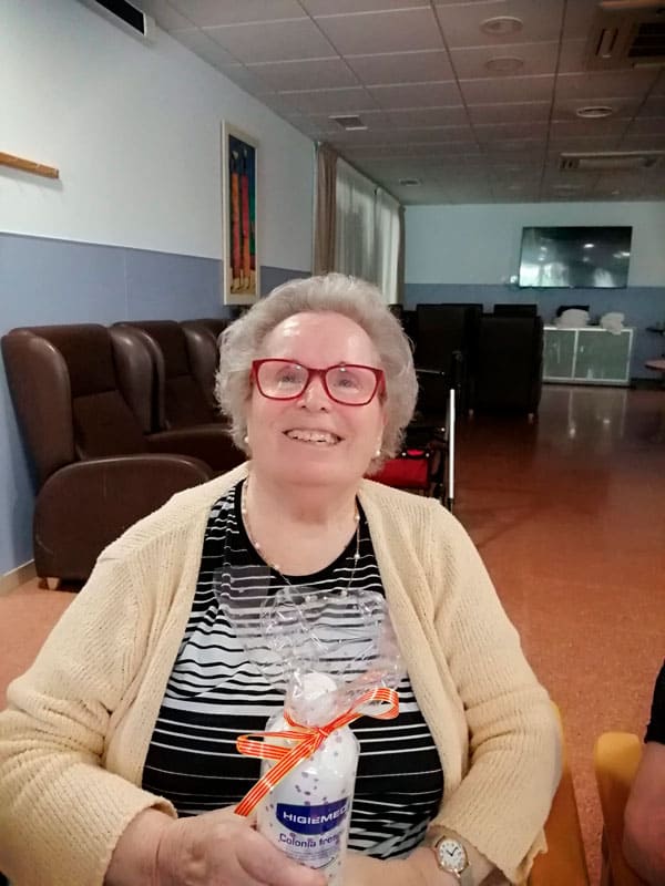 Otra residente cumpleañera sonríe mostrando su regalo