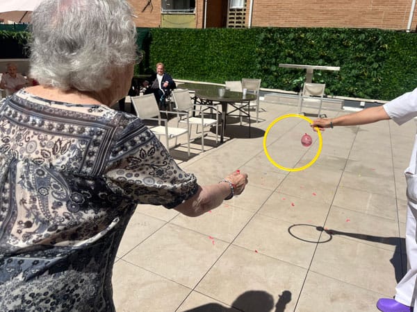 Una residente juega con pelotas y aros en el patio