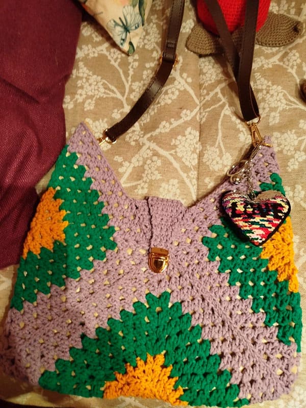 Bolso de ganchillo con diseño colorido y corazón decorativo para actividades de seniors.