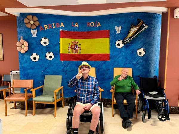 Un residente junto al mural con la bandera de España