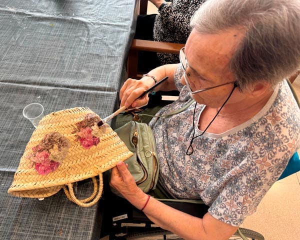 Residente pega flores decorativas al cestito