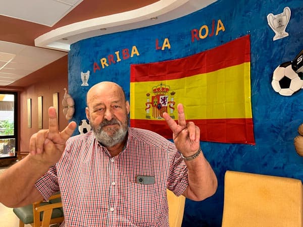 Un residente feliz posa junto al mural futbolístico