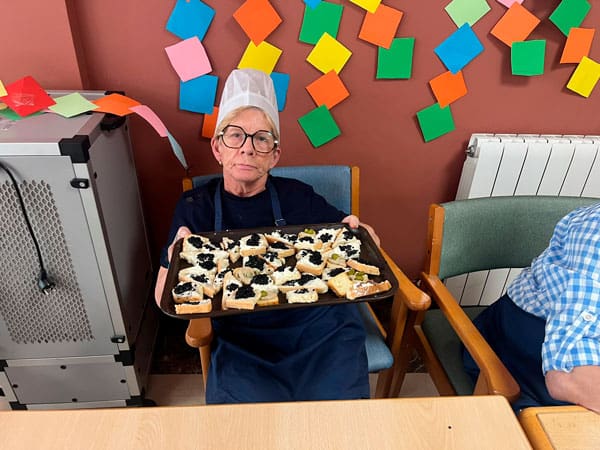 Una residente muestra orgullosa la comida elaborada