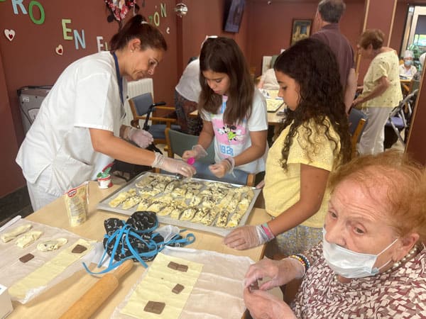 Los niños y niñas elaboran los cruasanes junto a los residentes