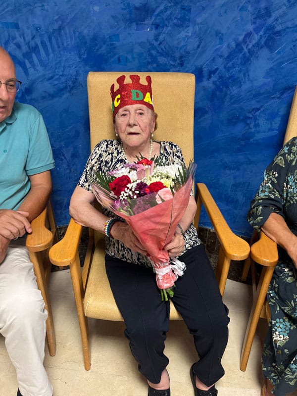 La residente cumpleañera junto al ramo de flores regalo de su cumpleaños
