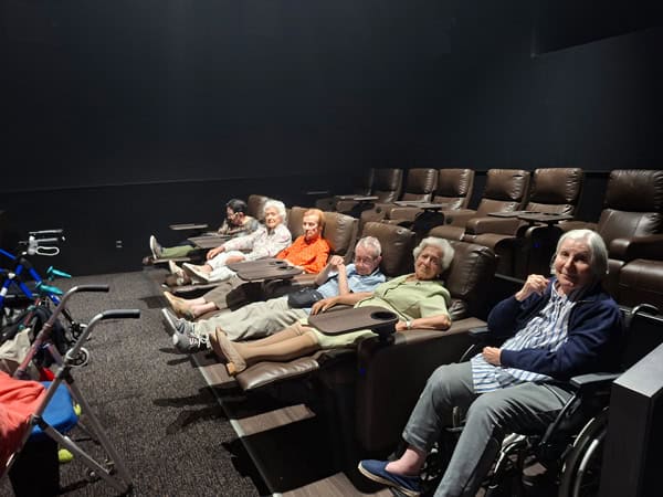 Los residentes posan sentados en las butacas del cine